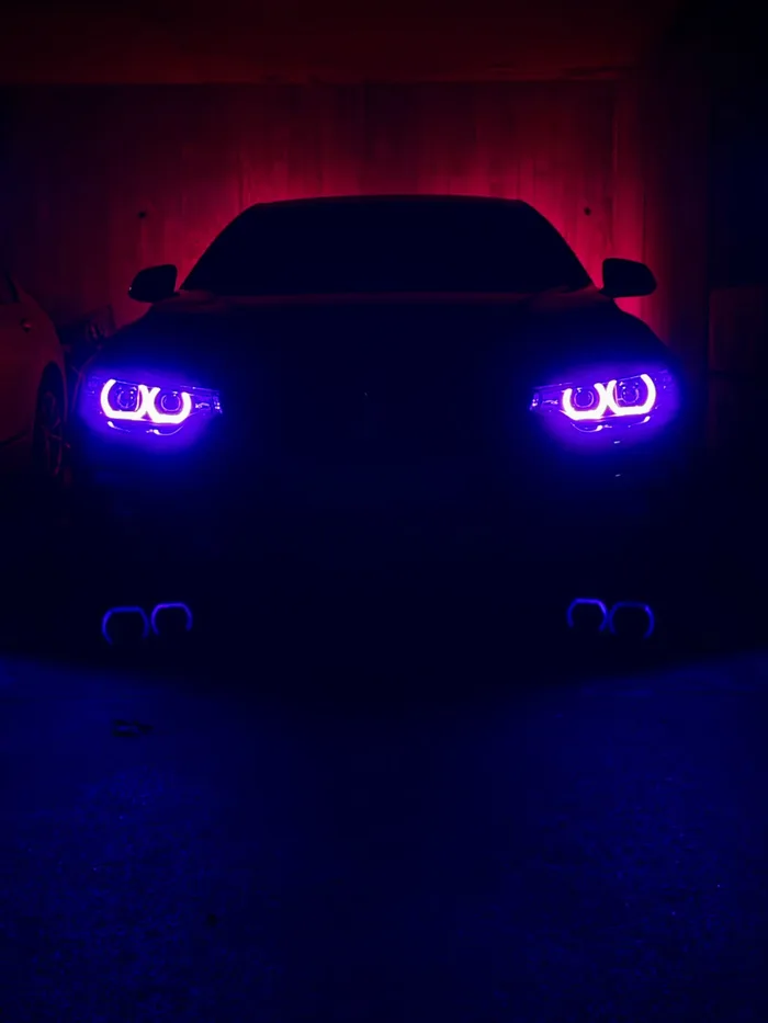 BMW-Front bei Nacht mit blau-violett leuchtenden Angel Eyes